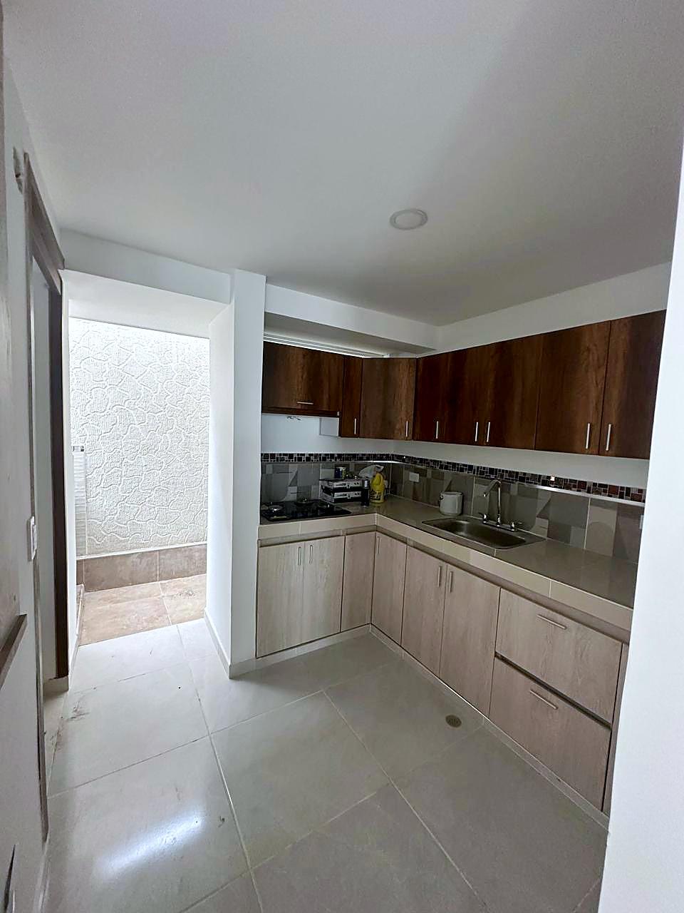 Cocina remodelada con muebles en madera clara y mesón